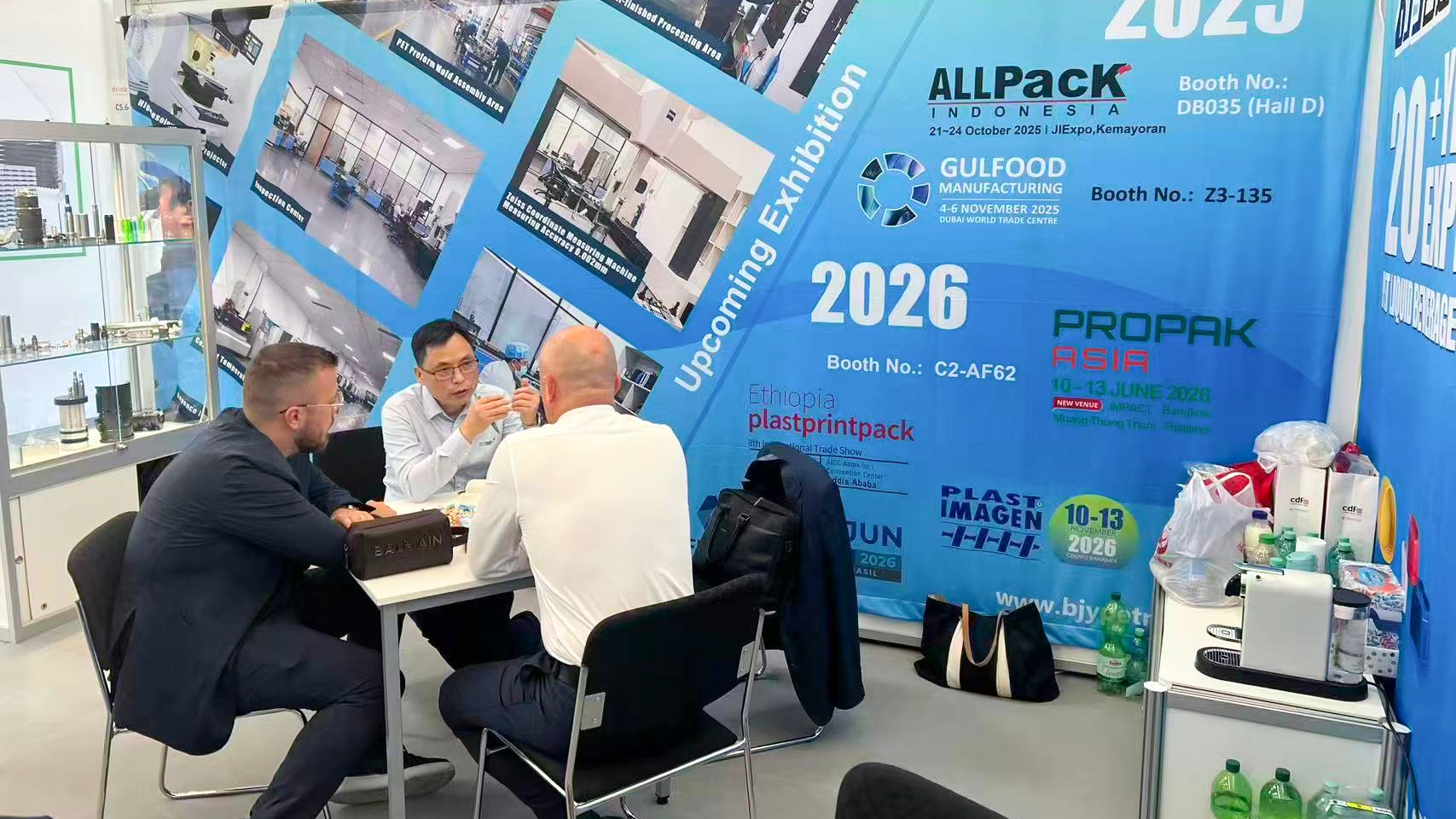Baijinyi representatives explaining cap mold specifications to a client at drinktec 2025, Munich.