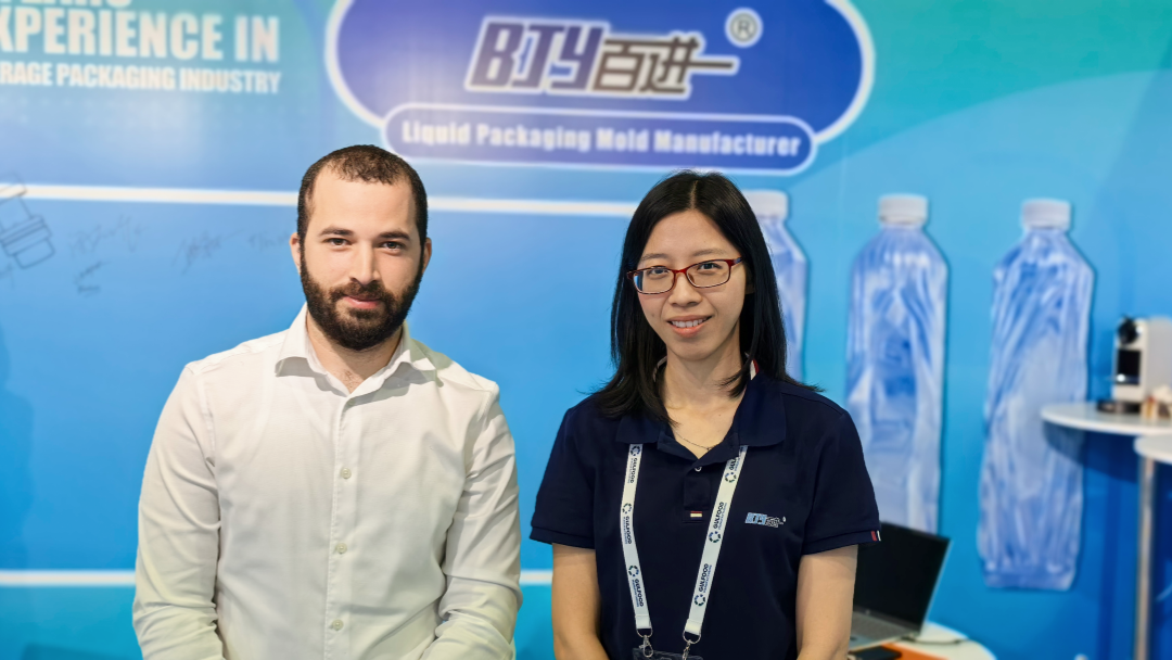 International visitors discussing blow mold and cap mold solutions with Foshan Baijinyi team at Gulfood 2025.